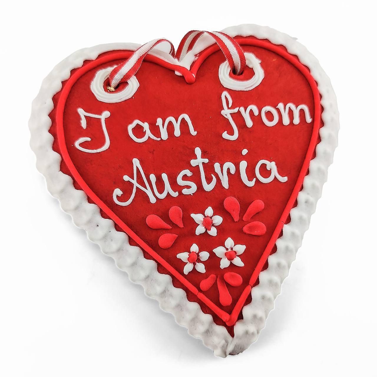 Rotes Lebkuchenherz mit weißem Rand, rot-weißem Band und der Aufschrift I am from Austria