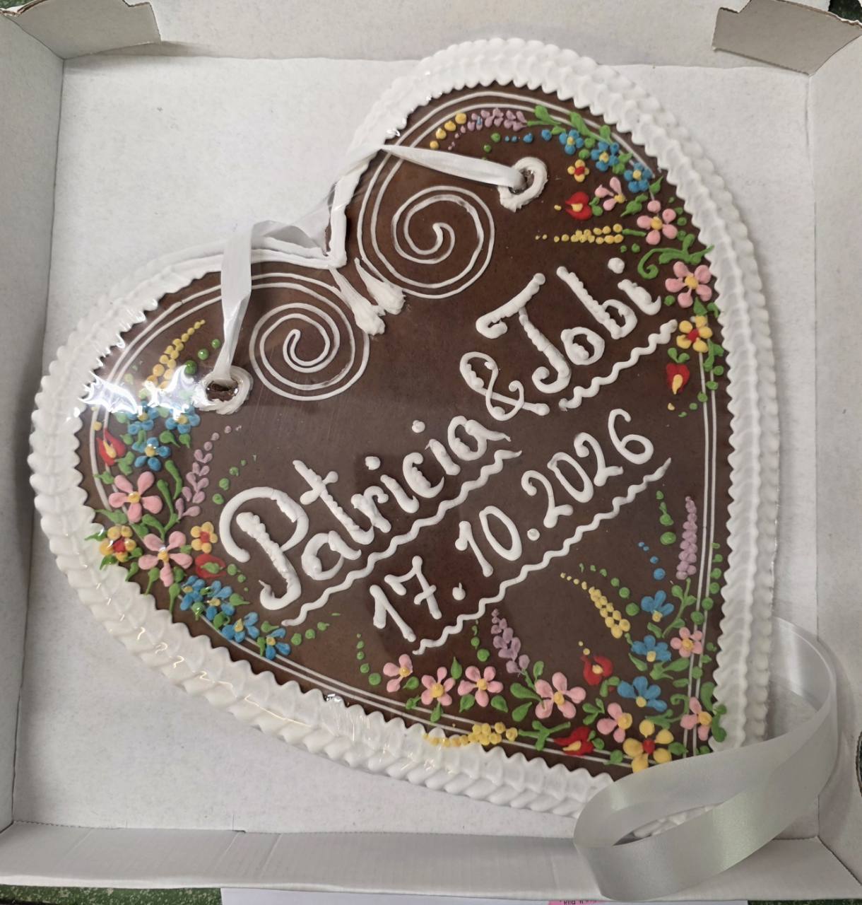 Hochzeitsherz für Patricia und Tobi mit Datum 17.10.2026, bunten Zuckerblumen und weißem Rand